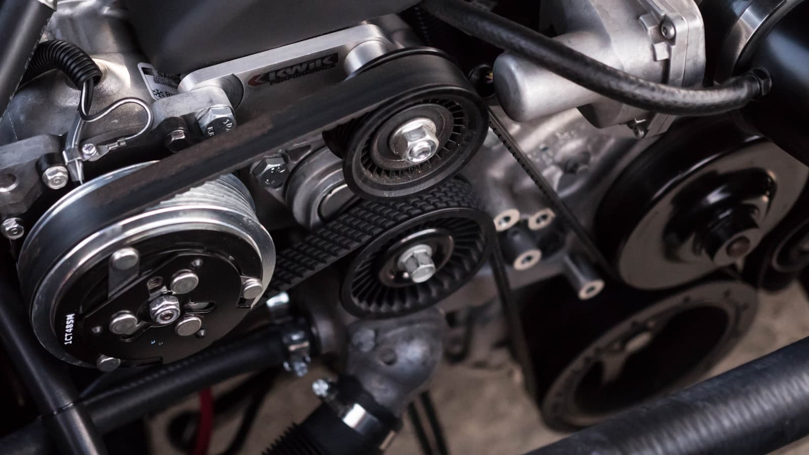 Close view of an engine accessory drive, belt, and pulleys during service